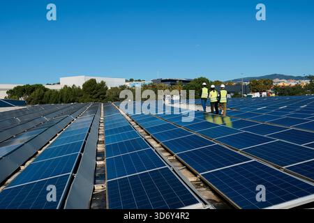 Engineers inspecting rooftop solar panel installation for renewable energy Stock Photo