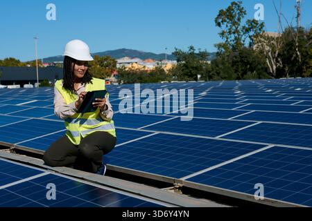 Woman engineer checking solar panels on rooftop Stock Photo