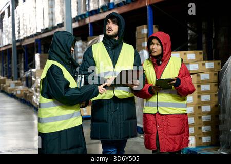 Cold chain logistics team discussing inventory in warehouse Stock Photo