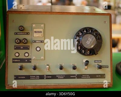 A vintage electronic control unit featuring a rotary dial, switches, connectors, and analog components. The device reflects classic engineering Stock Photo