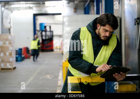 Worker managing cold chain logistics using tablet Stock Photo