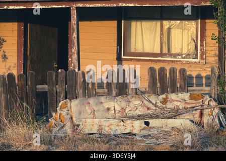Old couch in front a dilapidated building in Anatone, Washington, USA. Stock Photo