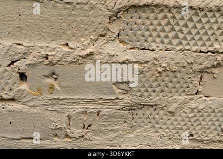 Textured beige painted brick wall with patterned surface detail Stock Photo