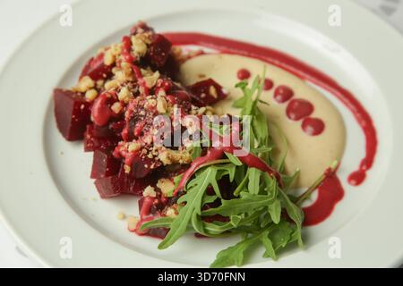 Beetroot salad served with hummus and fresh arugula Stock Photo