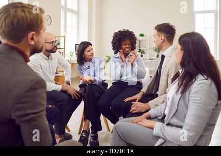 Coach or group leader telling funny, scary story, joke to amuse, teach diverse team Stock Photo