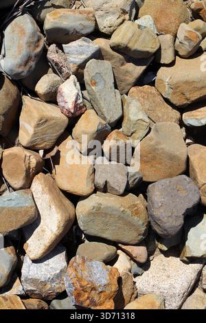 Pile of smooth rounded rocks stones abstract textured background Stock Photo