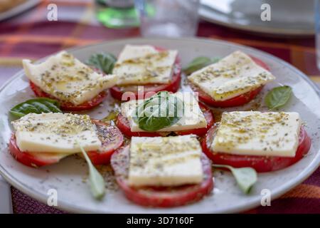 Caprese salad, slices of tomato, cheese of mozzarella ann spices, typical mediterranean meal Stock Photo