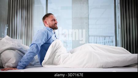 Sleepy Man Wakes Up Happy, Stretching Whole Body In Bed. Stock Photo