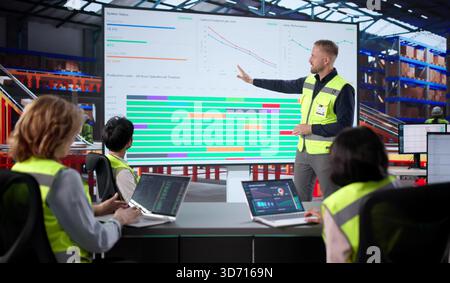 Warehouse Workers Meet With Manager, Analyze Data On Laptop Screen. African Team Discusses Supply Business Stock Photo
