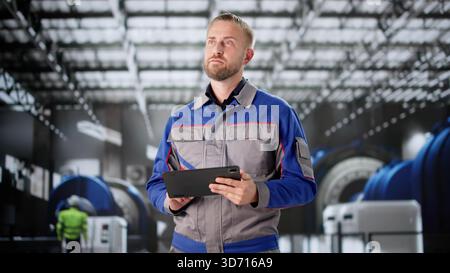 Young Male Engineer Inspecting Pipes For OSHA Regulations At Warehouse. Stock Photo