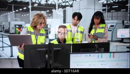 Engineers Control Industrial Machines Using Multiple Screens In Manufacturing Plant Stock Photo