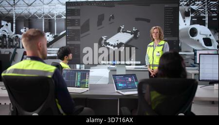 Engineers Collaborate On Electric Car Design In Industry Production Factory. Stock Photo