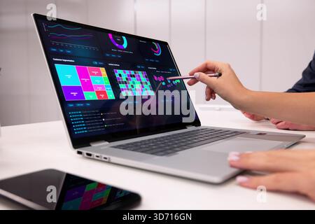 Businesswoman And Businessman Analyzing Financial Data On Laptop In Office. Stock Photo