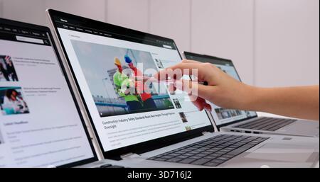 Digital Journalist Browsing Online News Website On Laptop Screen Stock Photo