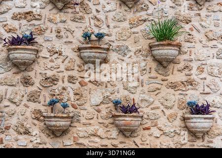 Rustic Stone Wall with Decorative Planters Stock Photo