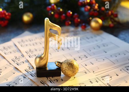 Golden music note, sheets and Christmas decor on table, closeup Stock Photo