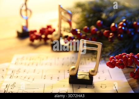 Golden music notes, sheets and Christmas decor on table, closeup Stock Photo
