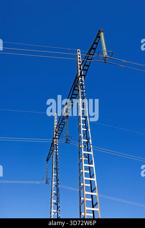 High voltage power line tower at a blue sky Stock Photo