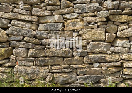 Traditional dry-stone wall with weathered rocks in a rural landscape. Stock Photo