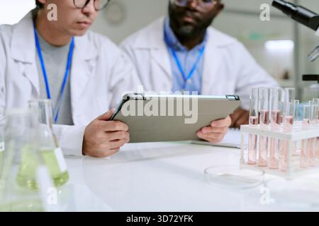 Man and Middle Aged Black Man Analyzing Data on Digital Tablet Stock Photo