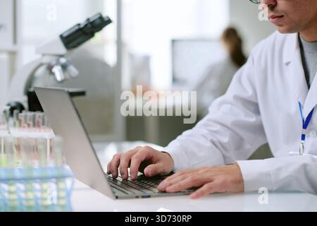 Young Adult Caucasian Man Working on Laptop in Modern Medical Laboratory Stock Photo