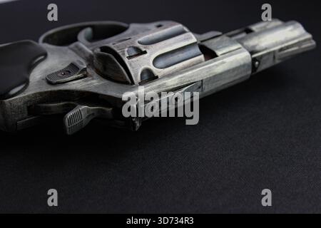 Close view of revolver underside with screws and frame details on black. Mechanics and engineering concept, dramatic light. Stock Photo