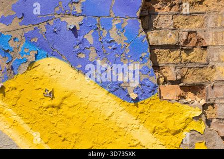 Blue and yellow old plaster on a brick wall. Abstract background. Stock Photo