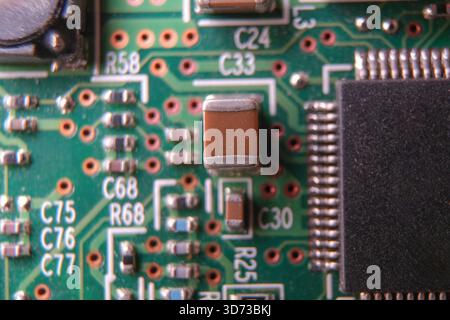 Surface mount technology capacitor on the electronic board. Selected focus. Stock Photo