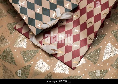 Decorative Christmas gift bags on festive wrapping surface. Stock Photo