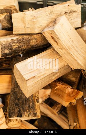 A pile of neatly stacked wood logs is prepared for a campfire or fireplace. The logs vary in color and texture, showcasing natural wood grains. This c Stock Photo