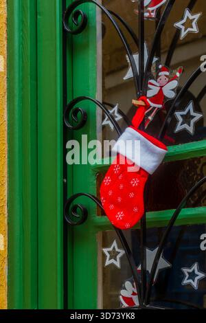 Festive Christmas Stocking Hung on Green Door With Star Decorations and Elf Clip Stock Photo