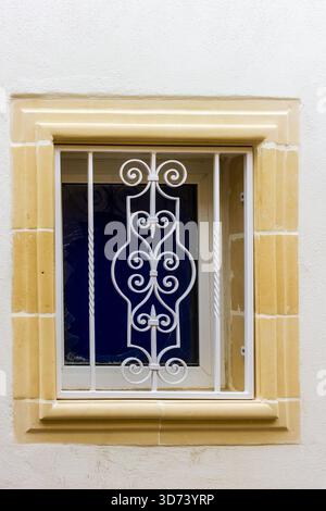 Ornate White Iron Window Grille With Beige Stone Frame On White Wall Stock Photo