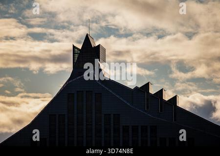 Architectural profile of the National Library of Latvia featuring stepped roof lines, pointed tower and geometric facade shapes contrasted against tex Stock Photo