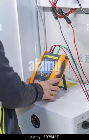 Technician uses measurement device to install solar system Stock Photo