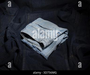 Light blue denim shorts lie on blue denim fabric Stock Photo