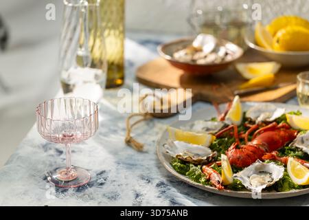 Fresh seafood platter with lobster, oysters, and lemon wedges arranged for a luxurious meal Stock Photo
