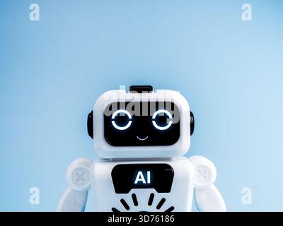 Cute AI robot with glowing eyes isolated on blue background, symbolizing artificial intelligence chatbot, friendly robotics, digital assistant, and fu Stock Photo
