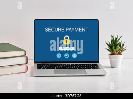 Secure online payment concept with laptop showing secure payment webpage with padlock icon and pay now button Stock Photo