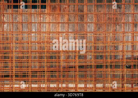 Closeup of rusty reinforcing steel mesh used in construction. Corroded steel reinforcement grid texture background. Selective focus. Stock Photo