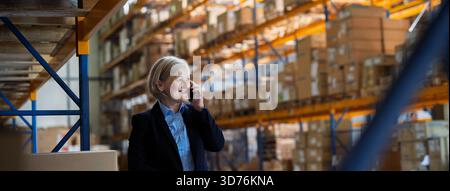 Banner of older industry of warehouse manager making phone call. Stock Photo