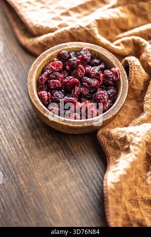 Tasty dried cranberries in bowl on a wooden table. Stock Photo