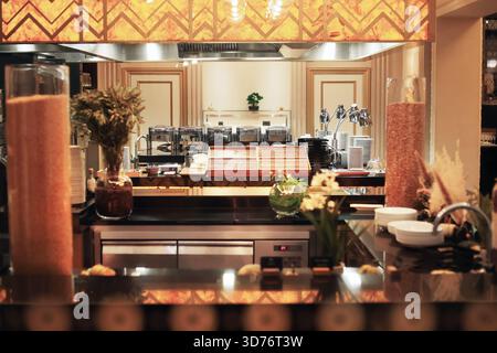 An elegant buffet area in a restaurant or hotel, featuring chafing dishes, dish stacks, decorative vases, and warm lighting. High quality photo Stock Photo