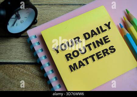Concept of your daily routine matters write on sticky notes isolated on Wooden Table. Stock Photo