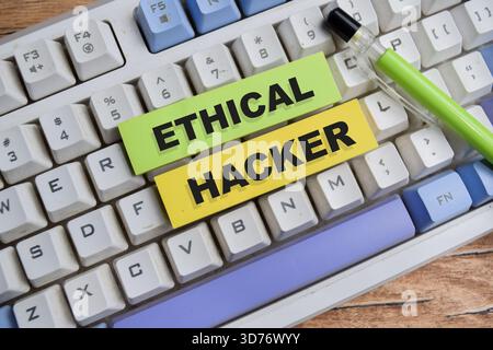 Concept of ethical hacker write on sticky notes isolated on Wooden Table. Stock Photo