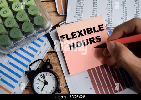 Concept of flexible hours write on sticky notes isolated on Wooden Table. Stock Photo