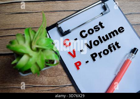 Concept of CVP - Cost Volume Profit write on clipboard isolated on Wooden Table. Stock Photo
