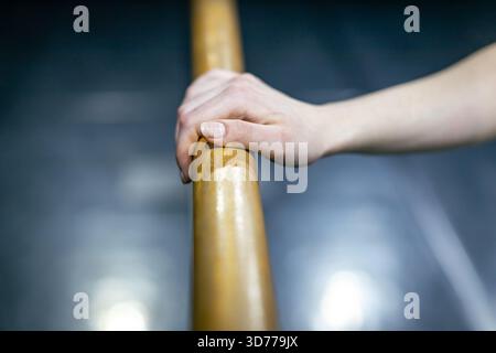ballerina's hand resting on ballet barre Stock Photo