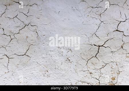 Close-up view of a cracked white painted straw wall texture Stock Photo