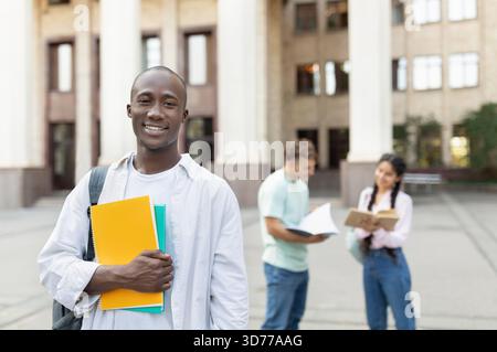 Students Engage in Study Session at University Campus During Sunny Afternoon With Focus on One Smiling Student Stock Photo