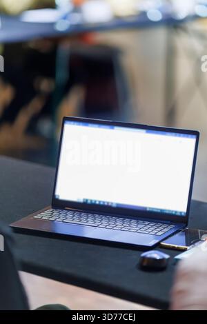 Open laptop on a conference table in an empty meeting room Stock Photo